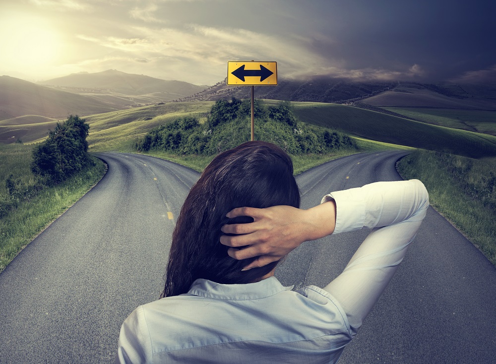 business woman in front of two roads thinking deciding growth fixed mindset